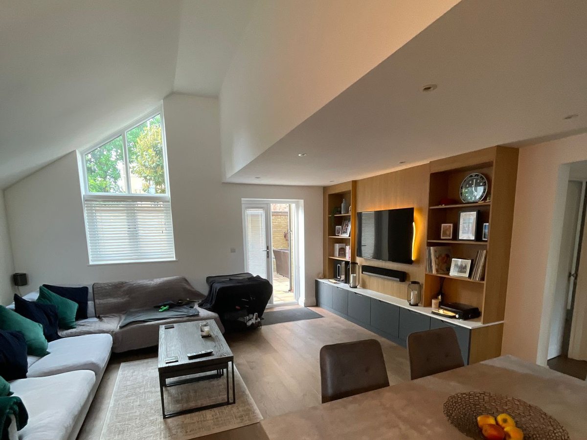 A bright South West London living room with a rug over hardwood flooring, the kind of space our carpet cleaning service keeps looking its best.