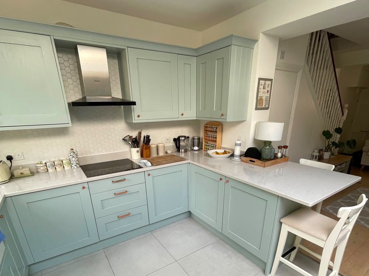 A bright, well-kept duck-egg blue kitchen in a South West London home — the standard a Clapham Homes regular clean maintains.